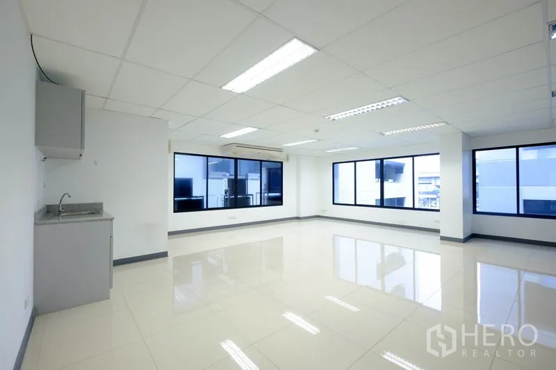 Office Space for rent in Chatuchak, Bangkok - Open workspace featuring a kitchenette, ceiling lights, and wide windows.