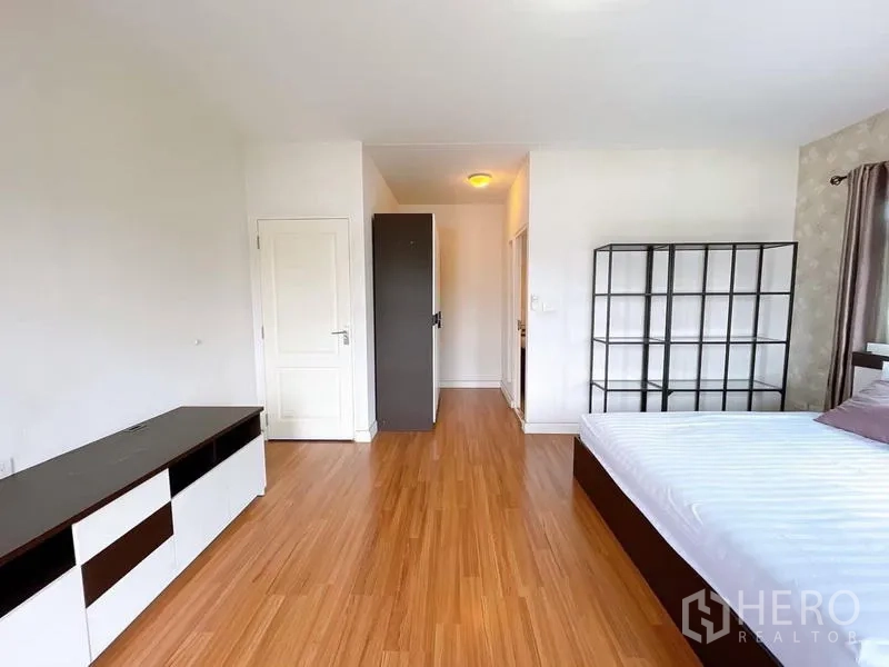 Detached House for rent in Bang Na, Bangkok - Master bedroom alternate view showing built-in shelves and ensuite corridor.