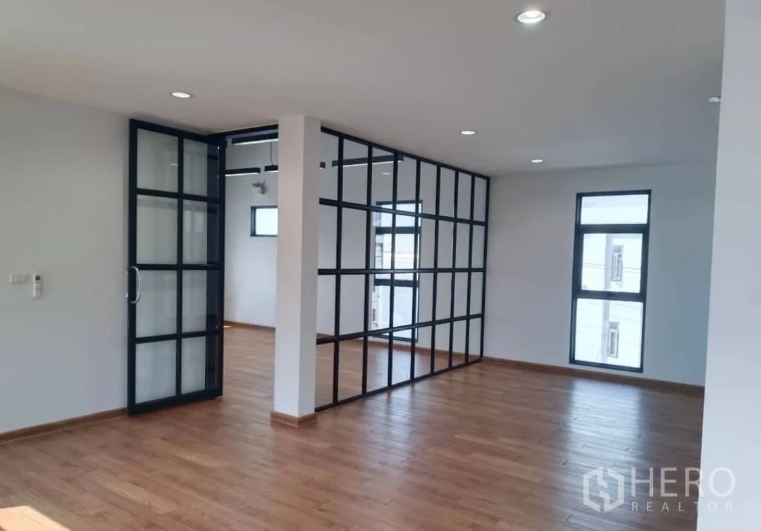 Factory for sale in Lam Luk Ka, Pathum Thani - Open plan office with grid glass partition and wood flooring.