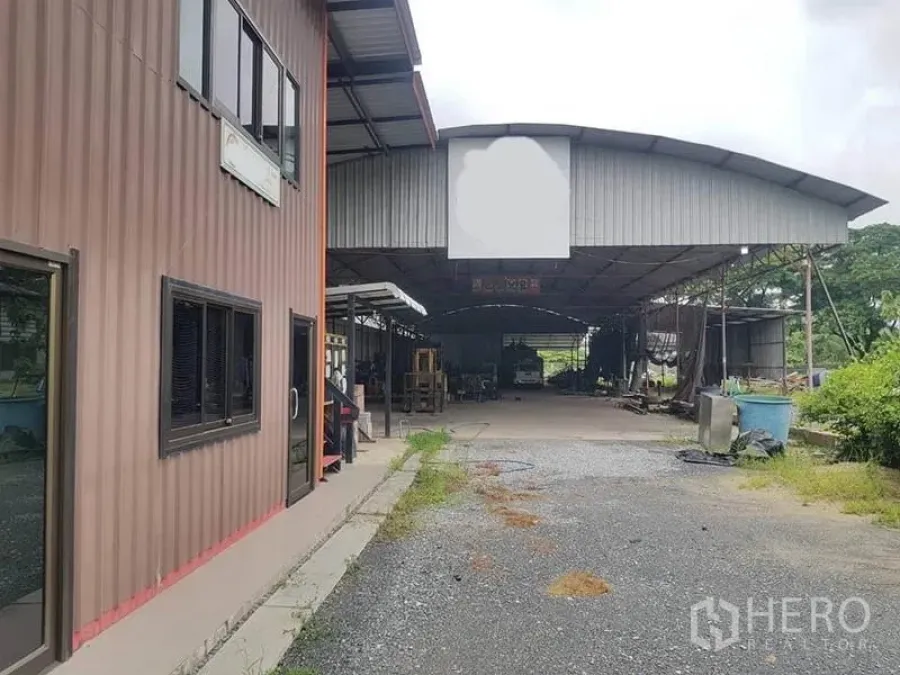 คลังสินค้า ให้เช่าในSai Noi, Nonthaburi - มุมมองด้านหน้าโกดังและอาคารสำนักงาน ลานจอดรถโรยหินกว้าง