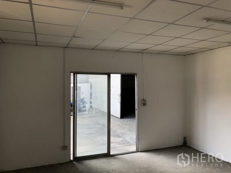 Warehouse for rent in Khlong Luang, Pathum Thani - Office area with sliding glass door opening to the warehouse loading yard.