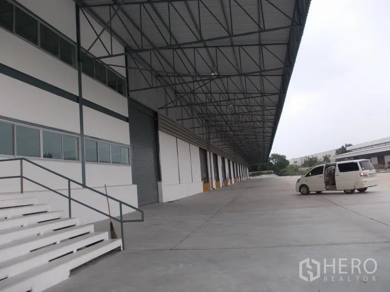 货栈 出租在Si Racha, Chon Buri - 宽阔雨棚卡车场，配卷帘门、台阶与充足回转空间