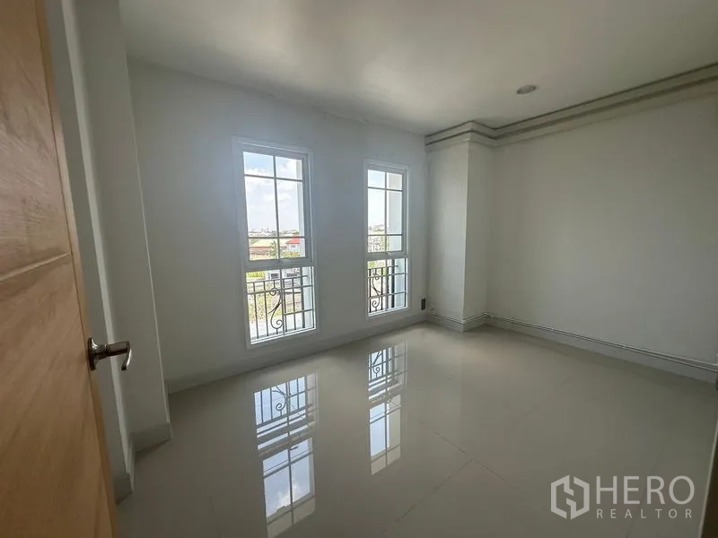 Home Office for rent in Bang Na, Bangkok - Sunlit corner room with three tall windows and city views.