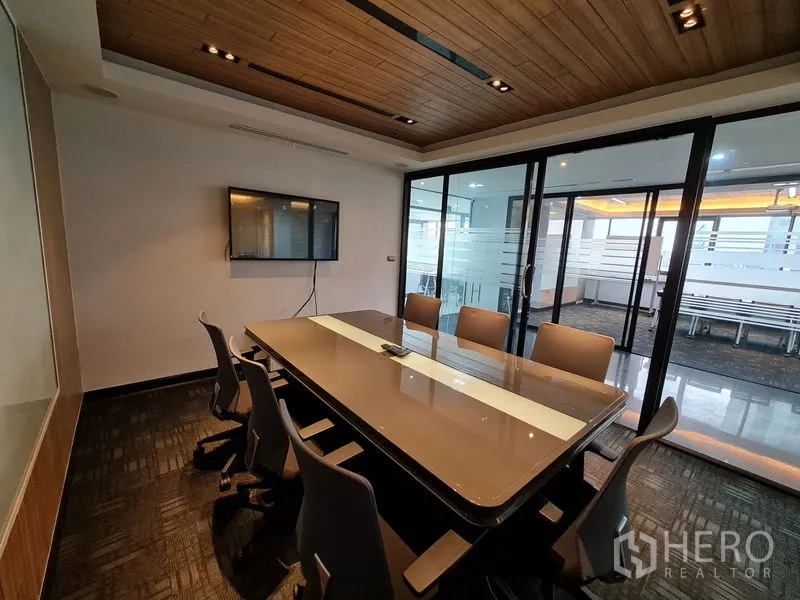 Office Space for rent in Bang Rak, Bangkok - Meeting room looking toward sliding glass doors and the reception beyond.