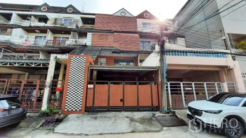 联排别墅 出租或出售在Suan Luang, Bangkok - 曼谷素安隆多层联排别墅外观，木质折叠大门与车棚。