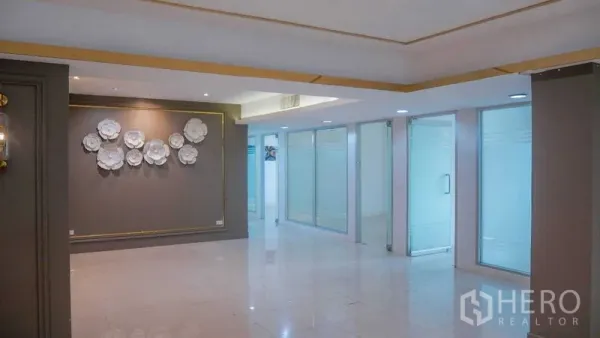 Office Space for rent in Chatuchak, Bangkok - Bright office reception with polished tile floors, feature wall art, and frosted‑glass rooms along the side.