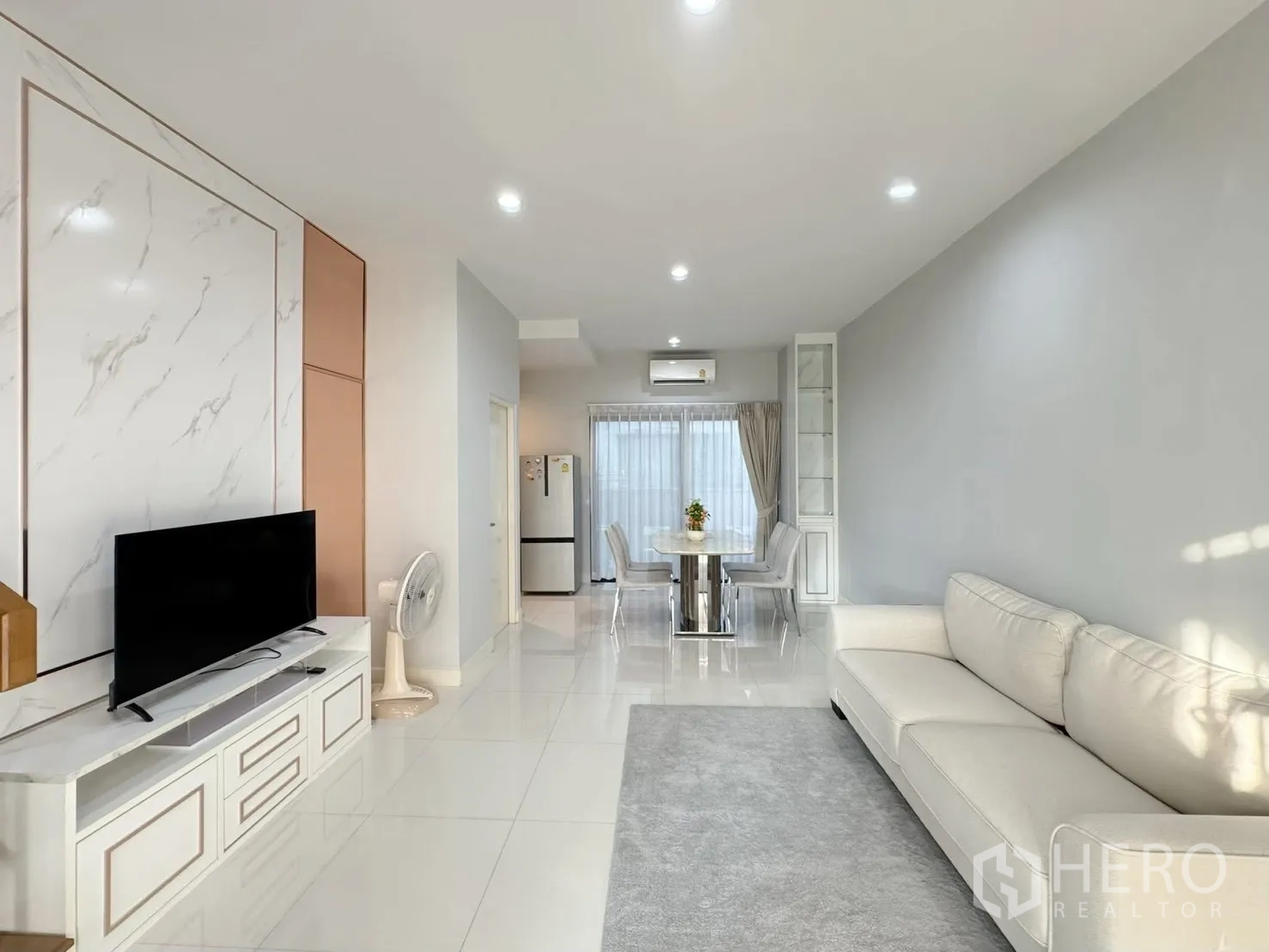 联排别墅 for rent in Saphan Sung, Bangkok - 开放式客厅，沙发、电视墙与亮面地砖