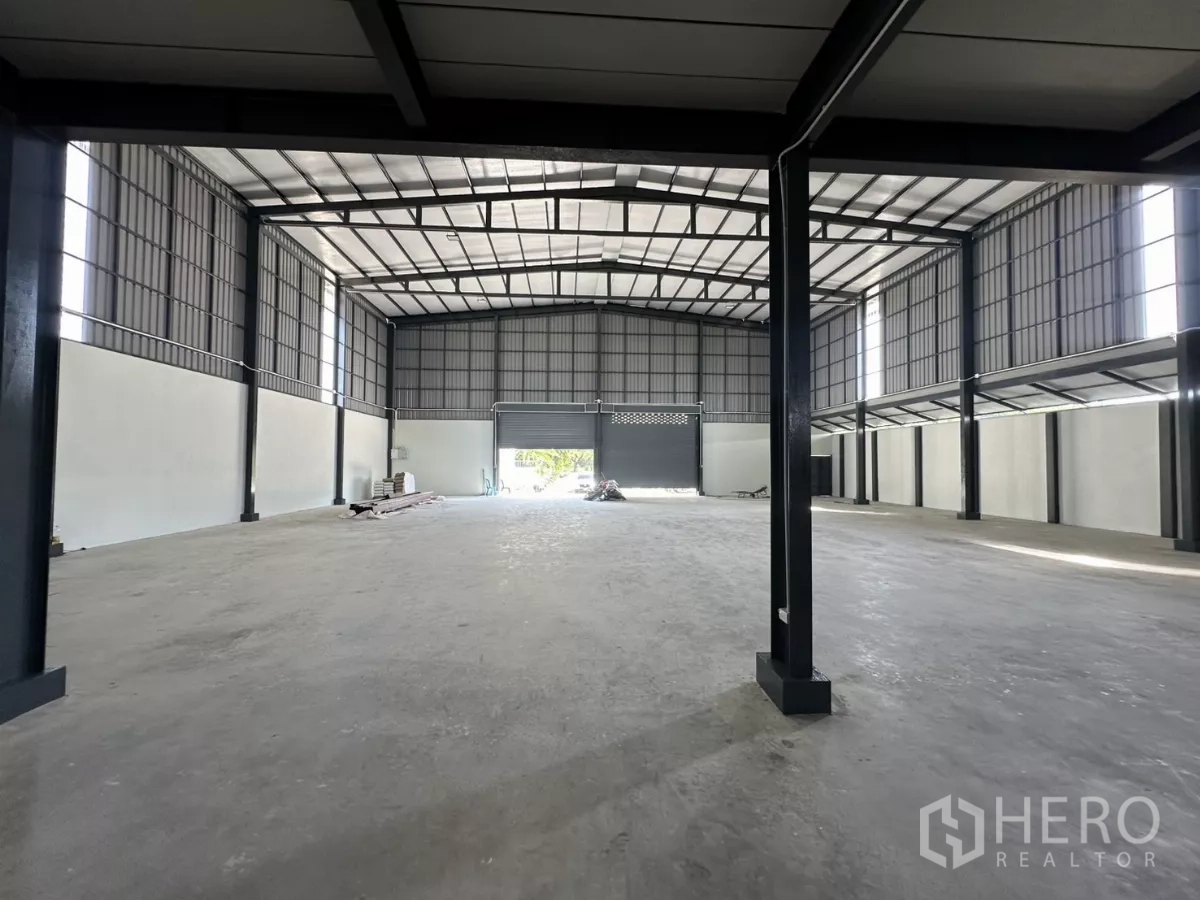 Warehouse for rent in Prawet, Bangkok - Open storage hall with high ceiling, natural light and a rear roller door.