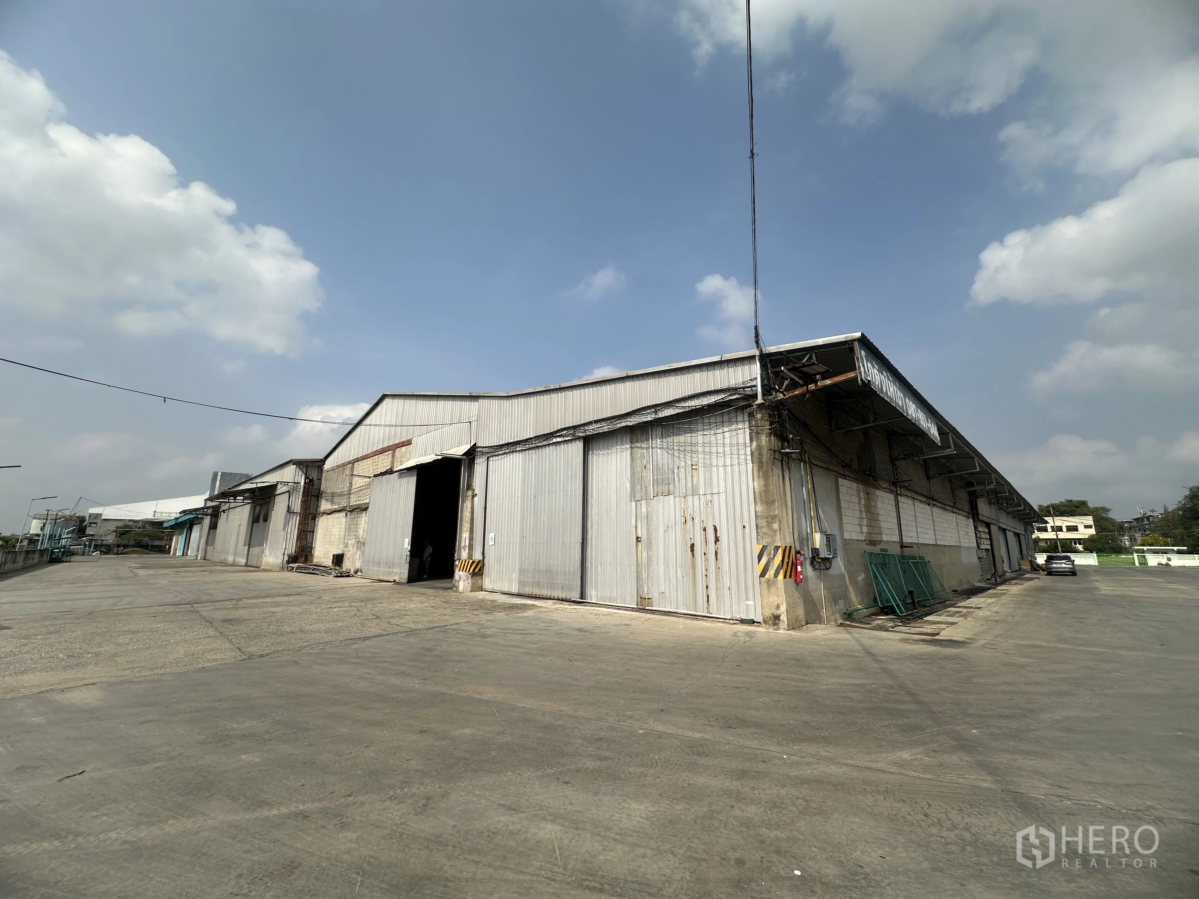 货栈 for rent in Mueang Pathum Thani, Pathum Thani - 多联仓库金属外墙，车道宽敞，适合集装箱卡车进出。