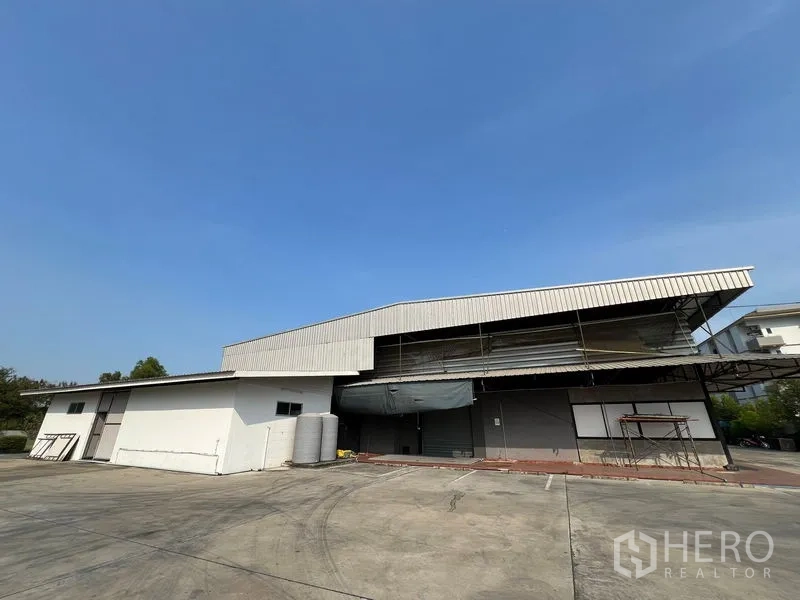 คลังสินค้า ให้เช่าในSaphan Sung, Bangkok - มุมมองด้านหน้าโกดังพร้อมลานคอนกรีตกว้างและที่จอดรถ