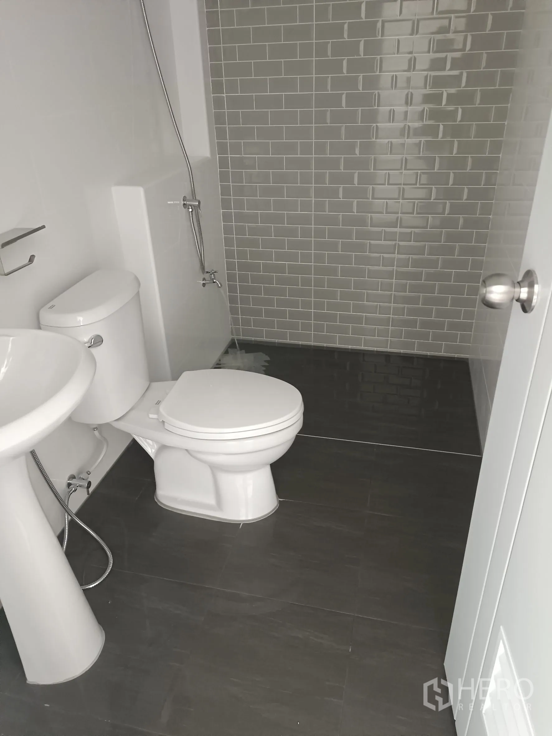 Warehouse for rent or sale in Bang Yai, Nonthaburi - Modern bathroom with gray subway‑tile shower, pedestal sink and toilet.