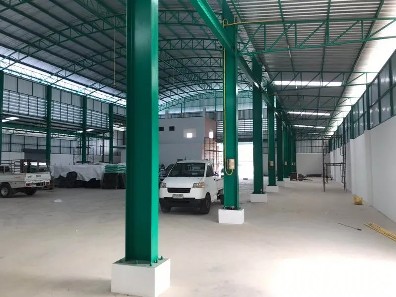 工厂 出租或出售在Mueang Samut Sakhon, Samut Sakhon - 内部视角，绿色钢柱与宽阔车道可供车辆进出。