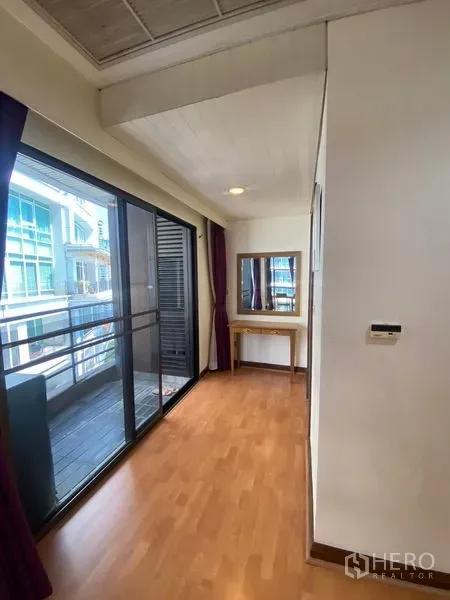 Condominium for rent in Pathum Wan, Bangkok - Hallway dressing space with sliding glass to the balcony and a vanity table by the window.