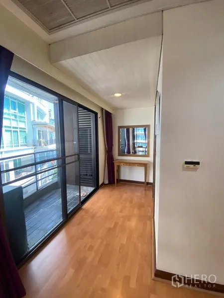Condominium for rent in Pathum Wan, Bangkok - Hallway dressing space with sliding glass to the balcony and a vanity table by the window.