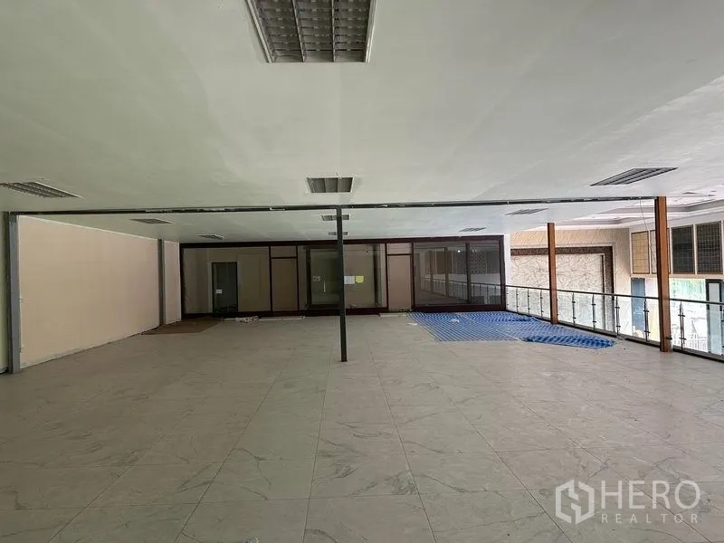 货栈 出租在Lam Luk Ka, Pathum Thani - 二层办公室夹层，玻璃栏杆与大块瓷砖地。