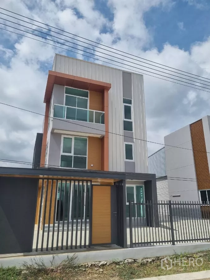 Warehouse for sale in Lam Luk Ka, Pathum Thani - Street view of gated three-storey home office facade.