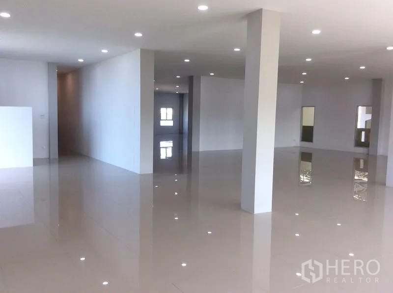 Factory for sale in Bang Sao Thong, Samut Prakan - Open-plan office floor with columns, LED downlights and shiny tile flooring.