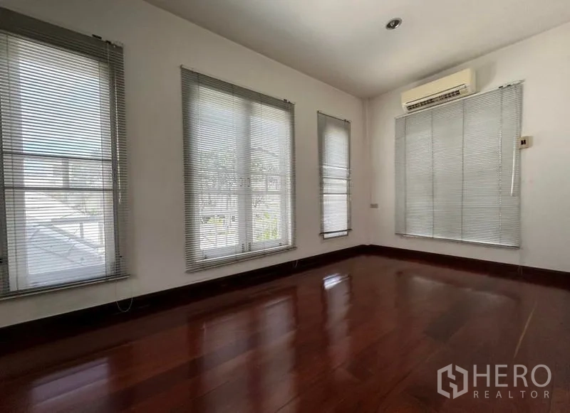 Home Office for rent in Suan Luang, Bangkok - Sunlit bedroom with polished wood floors and window blinds.