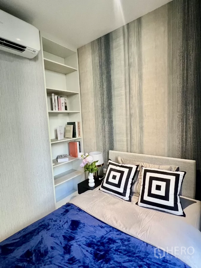 Condominium for rent in Khlong Toei, Bangkok - Bedroom corner with built-in shelving and a patterned feature wall.