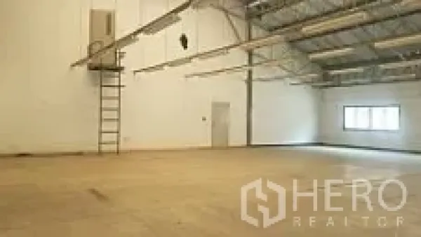 Factory for sale in Lam Luk Ka, Pathum Thani - Spacious warehouse hall with high roof trusses, wall ladder and clear working area.
