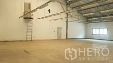Factory for sale in Lam Luk Ka, Pathum Thani - Spacious warehouse hall with high roof trusses, wall ladder and clear working area.