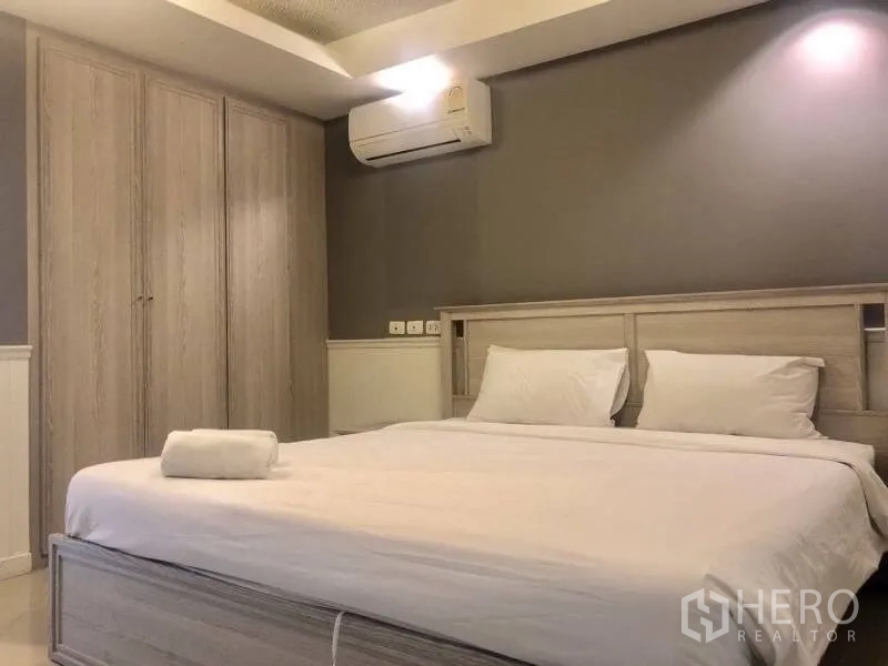 Condominium for rent in Khlong Toei, Bangkok - Master bedroom with king bed, built-in wardrobe and warm downlights.