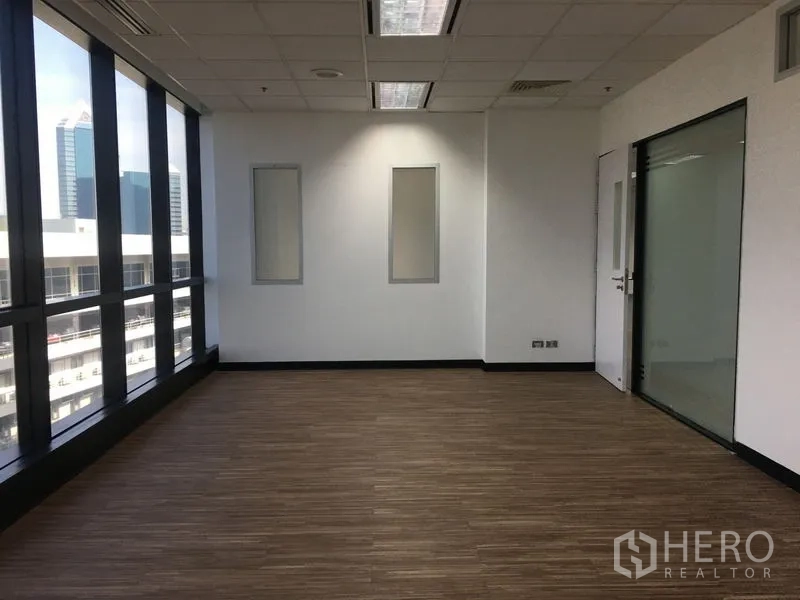 Office Space for rent in Chatuchak, Bangkok - Corner office with wood flooring, full-height windows, and city skyline views.