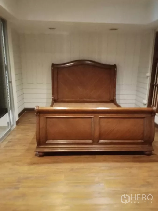 Home Office for rent in Lat Phrao, Bangkok - Bedroom with wooden bedframe and white panel walls