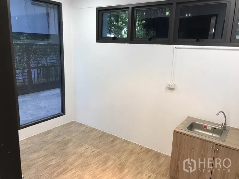 Retail Space for rent in Watthana, Bangkok - Compact back room with pantry sink, base cabinet and high windows, ideal as a preparation or staff area.
