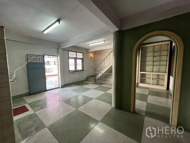 Shophouse for rent in Suan Luang, Bangkok - Open retail area showing windows and a staircase to the upper floors.