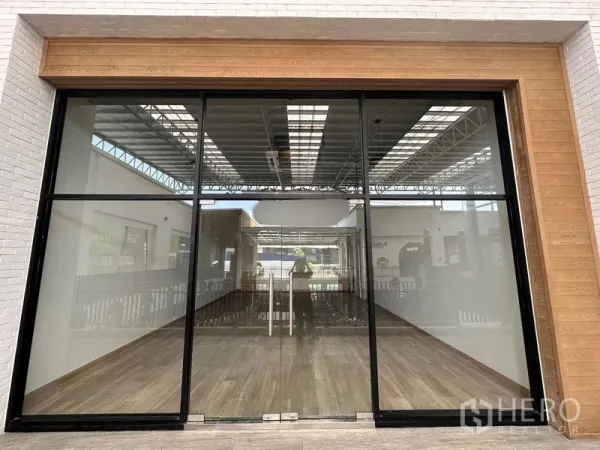Retail Space for rent - Floor-to-ceiling glass storefront with timber trim and wood-look flooring inside the retail unit.