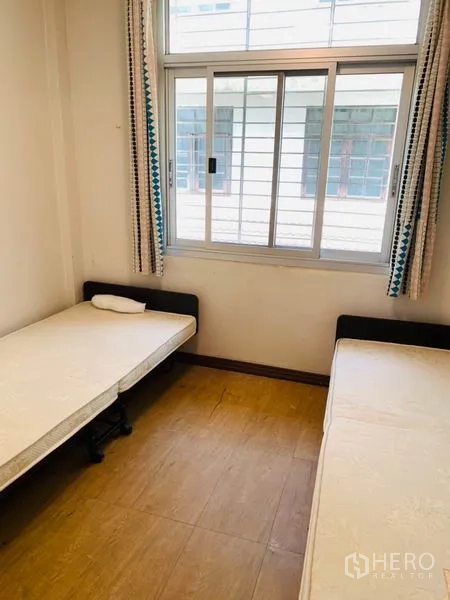 联排别墅 出租或出售在Huai Khwang, Bangkok - 客卧，两张单人床与推拉窗，木纹地板