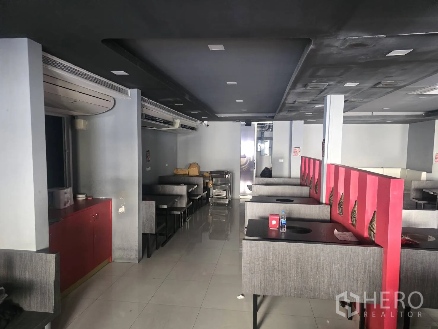 Retail Space for rent in Khlong Toei, Bangkok - Open-plan retail interior with booth seating, red accents, tiled floor and dark ceiling in Khlong Toei.