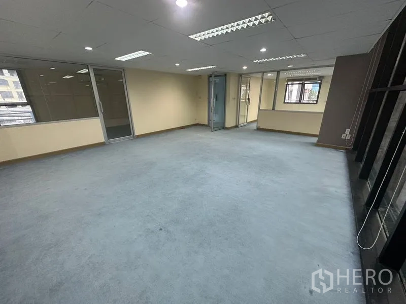 办公空间 出租在Bang Rak, Bangkok - 开放工位区，玻璃隔间与大窗户引入自然光。