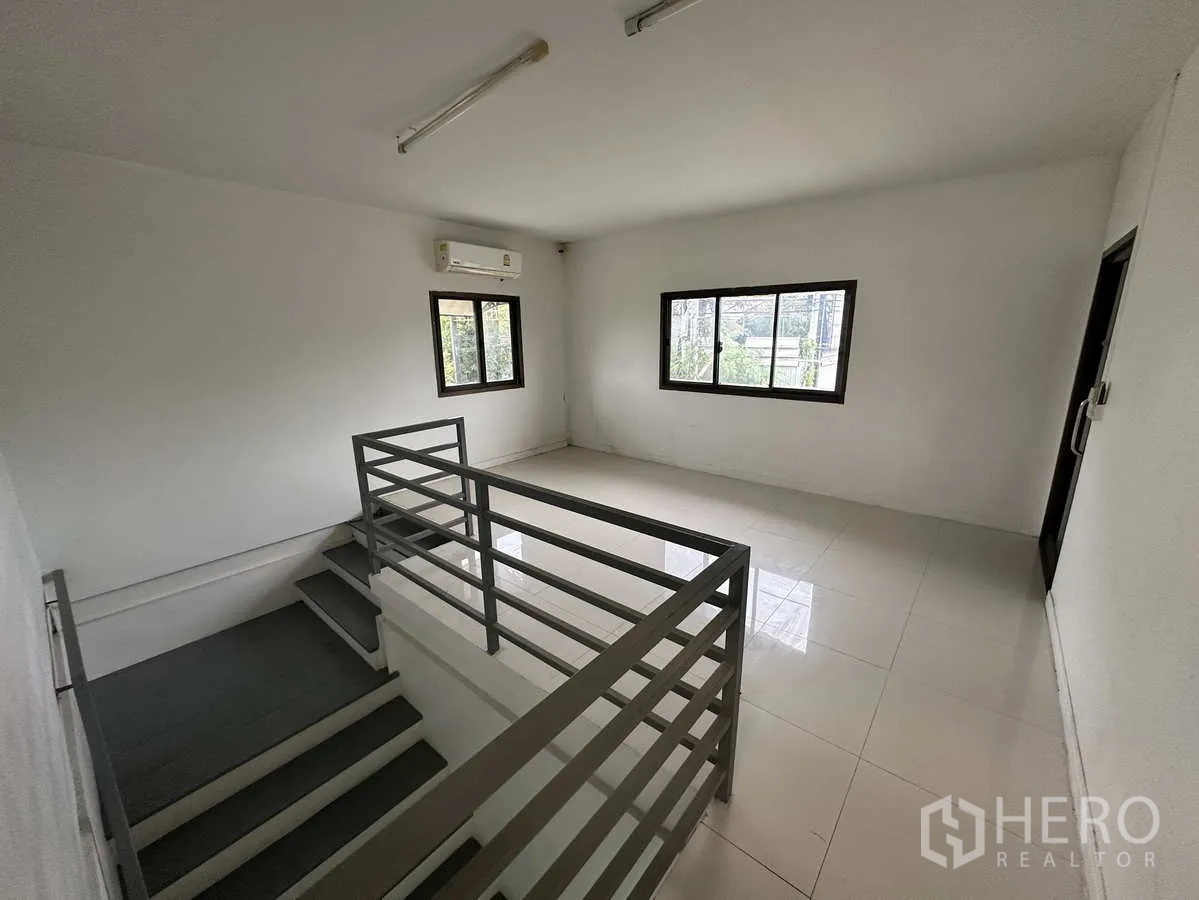 Factory for rent or sale in Bang Yai, Nonthaburi - Stair landing to second-floor offices with windows and white tiled floors.