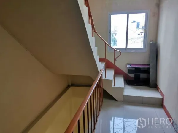 Shophouse for rent in Suan Luang, Bangkok - Internal staircase with handrail and window bringing natural light.