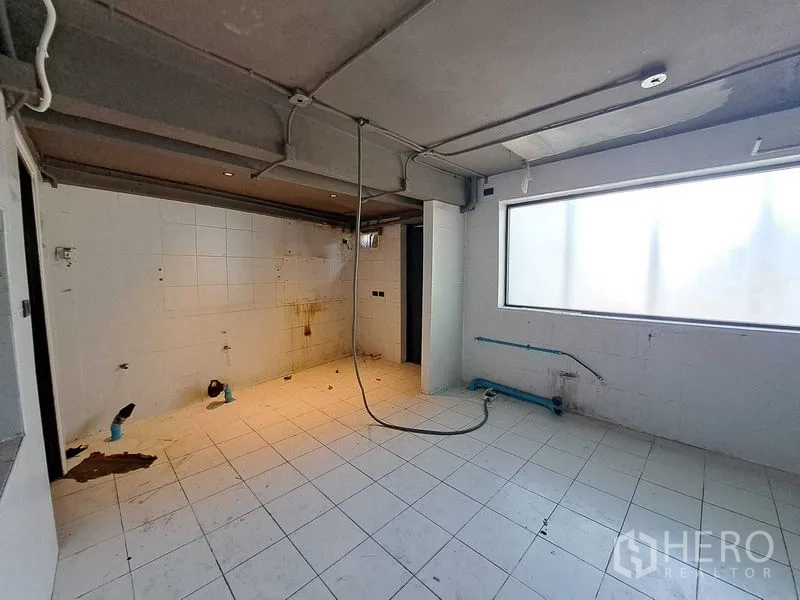 Retail Space for rent in Watthana, Bangkok - Back-of-house tiled room with plumbing and a large frosted window, suitable for kitchen or storage.