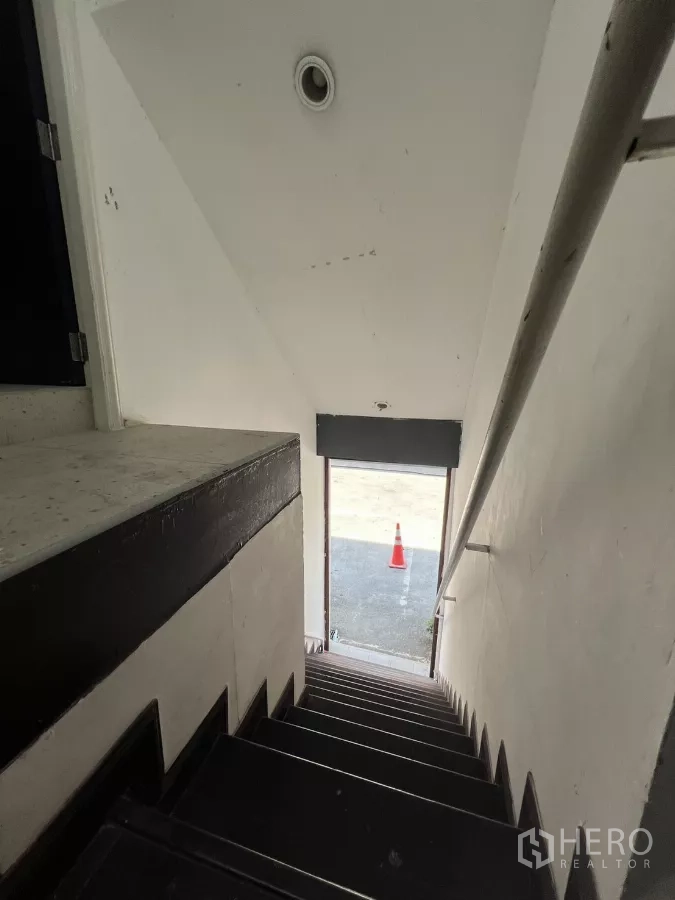 Retail Space for rent - Stairwell looking down to ground‑floor exit and driveway.