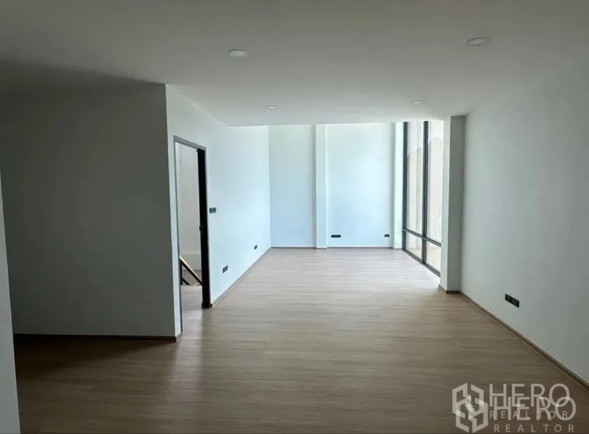 Warehouse for sale in Lam Luk Ka, Pathum Thani - Long office corridor with full-height glazing and a separate room at the end.