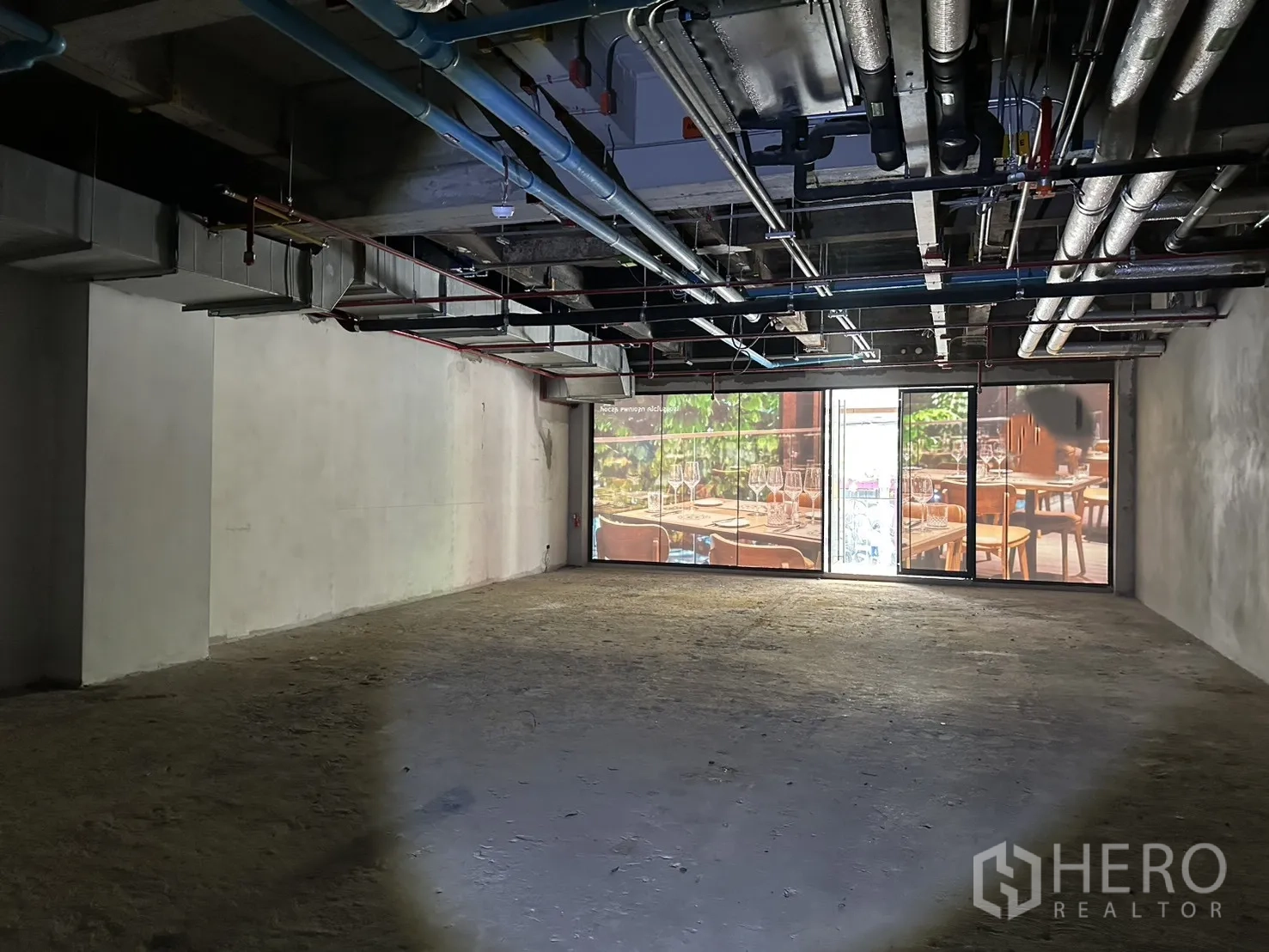 Retail Space for rent in Bang Rak, Bangkok - Wide glass storefront with sliding door bringing light into the empty unit.