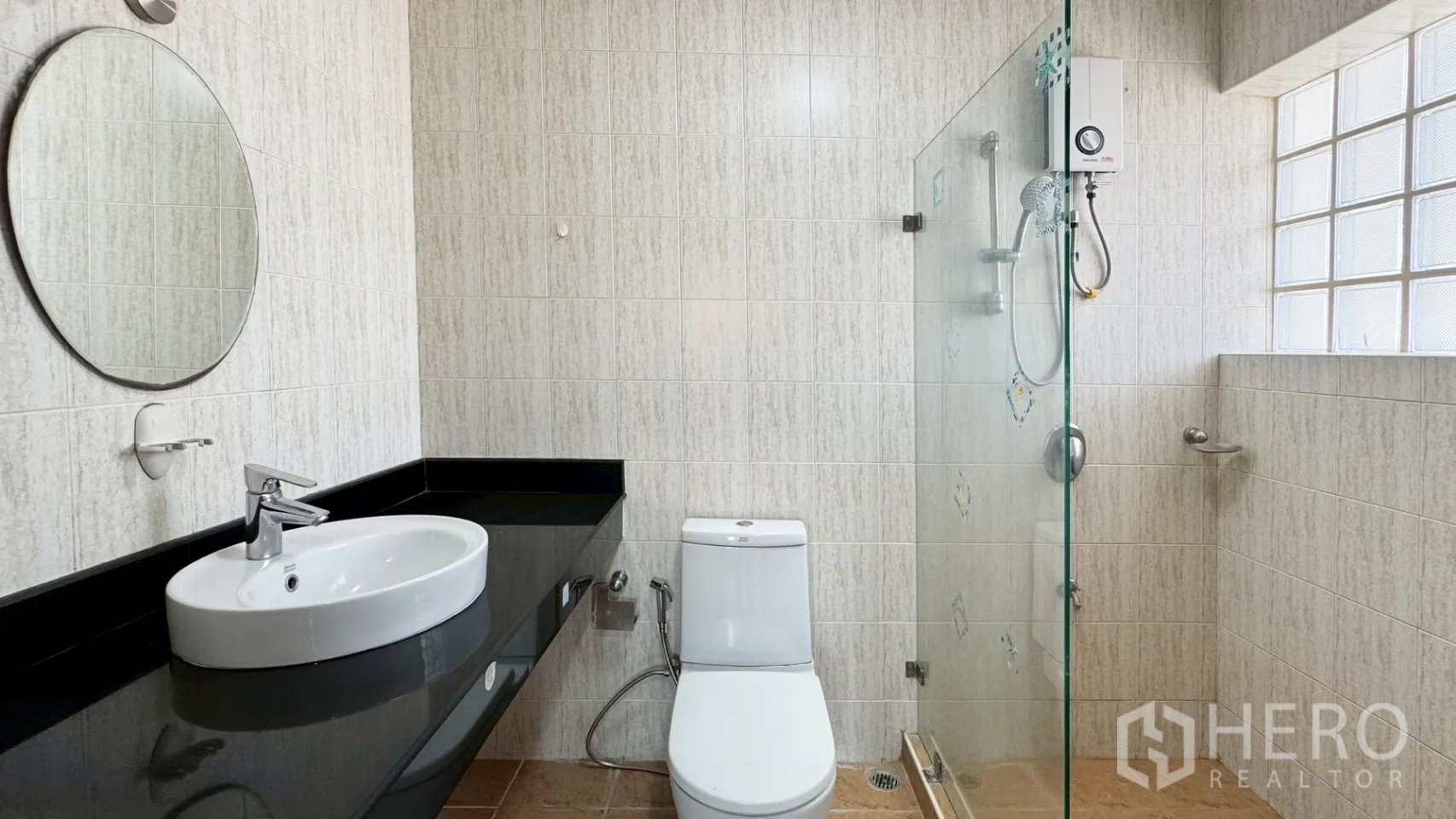 บ้านเดี่ยว for rent in Suan Luang, Bangkok - ห้องน้ำพร้อมฉากกั้นอาบน้ำกระจก กระจกทรงกลม เคาน์เตอร์ท็อปสีดำและโถสุขภัณฑ์