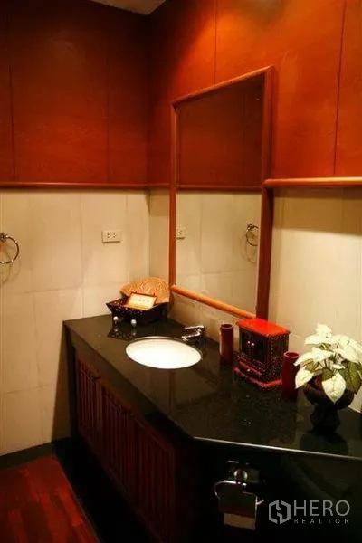 Detached House for rent in Phaya Thai, Bangkok - Bathroom vanity with under-mount sink, wood cabinetry and warm lighting.