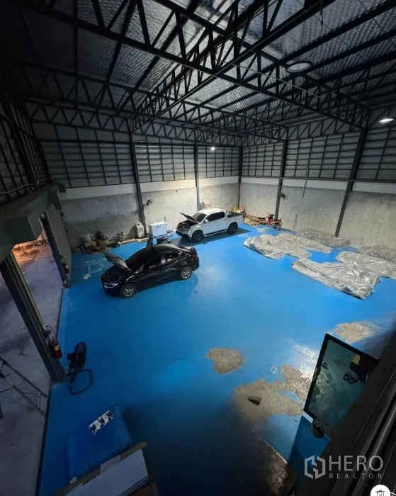 Warehouse for sale in Thanyaburi, Pathum Thani - High-ceiling warehouse interior with blue epoxy floor and open work space.