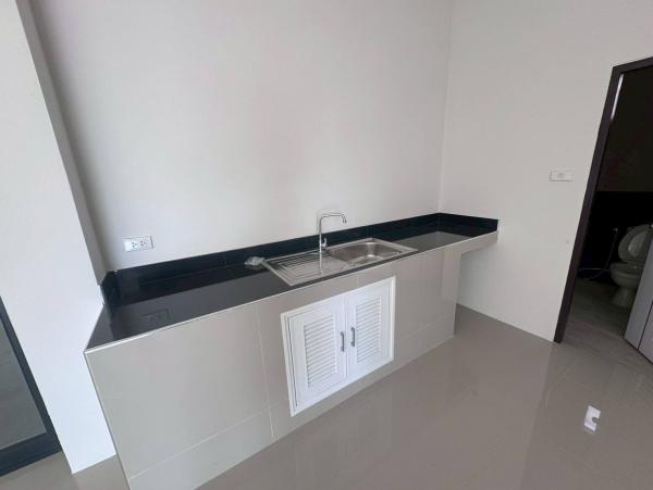 Factory for sale in Mueang Samut Sakhon, Samut Sakhon - Built-in pantry with black countertop, stainless sink and tiled finish.