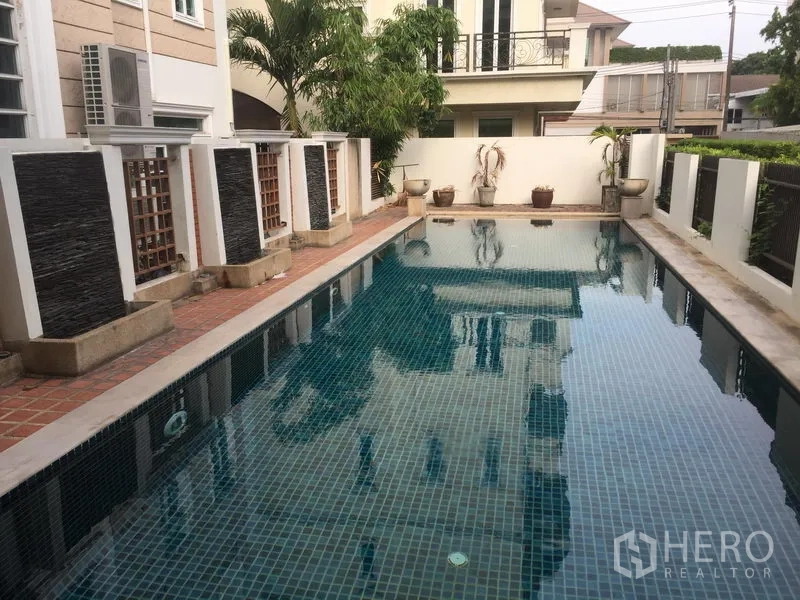 Townhouse for sale in Huai Khwang, Bangkok - Communal swimming pool beside the townhouse with tiled deck and privacy walls.