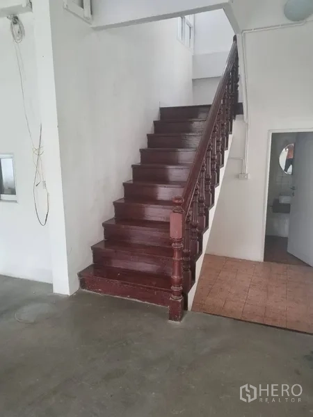 Detached House for rent or sale in Sathon, Bangkok - Ground floor showing wooden staircase and adjacent bathroom entrance.