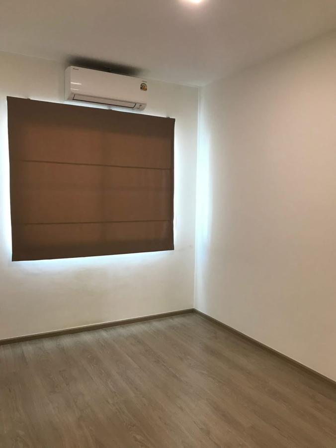 Townhouse for rent in Prawet, Bangkok - Air‑conditioned room with brown blackout blinds and wood laminate flooring.