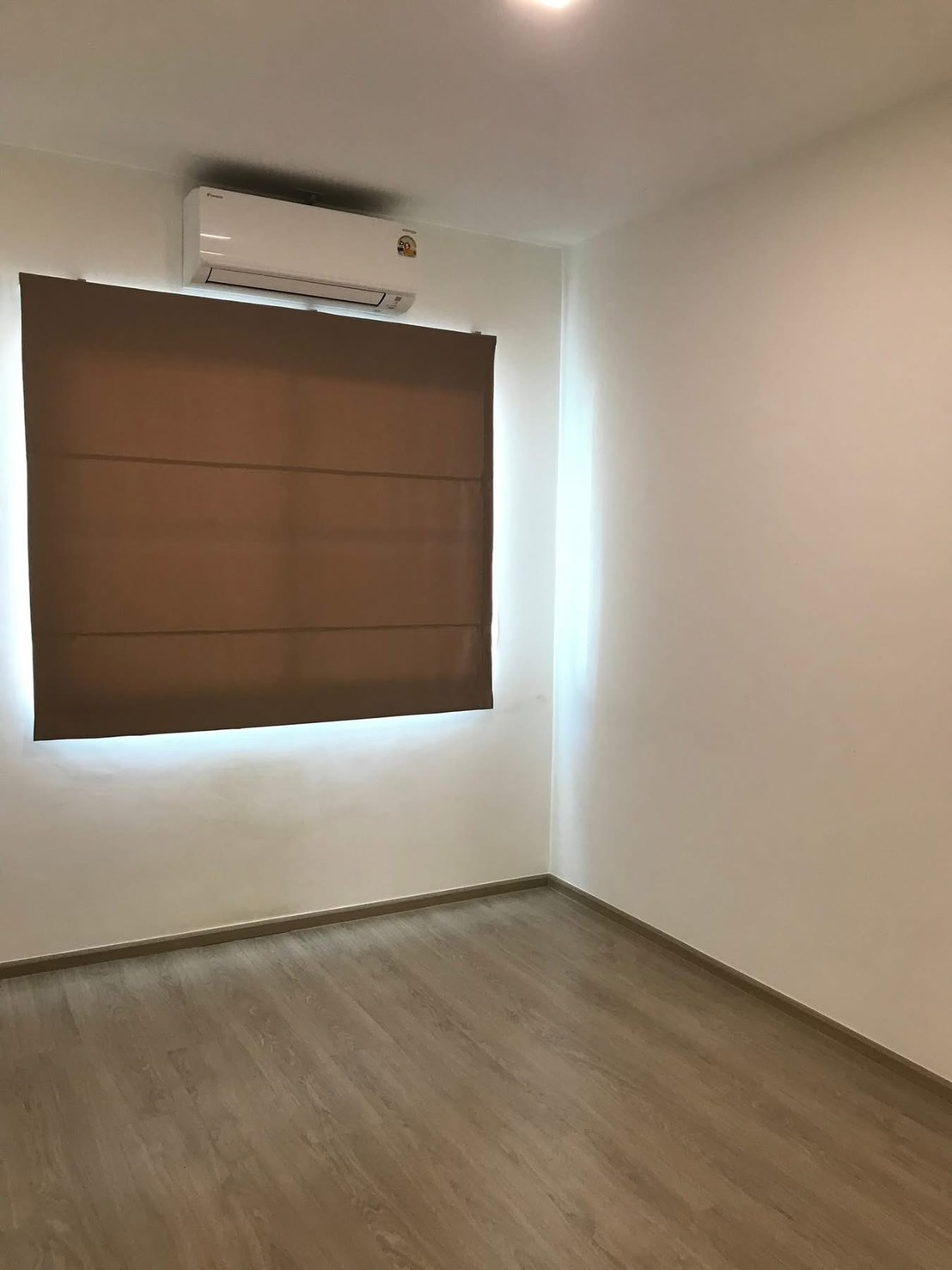 联排别墅 for rent in Prawet, Bangkok - 带空调的房间，棕色遮光窗帘与木纹地板。