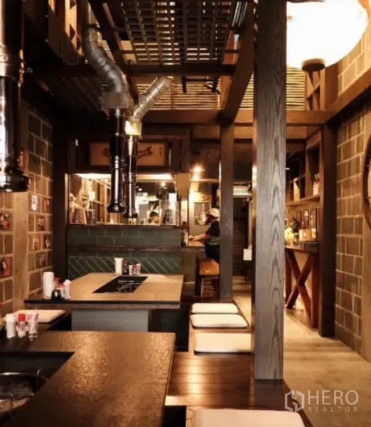 Shophouse for rent in Bang Rak, Bangkok - Warm timber-and-brick interior with built-in tables and ventilation ducts, ideal for F&B.