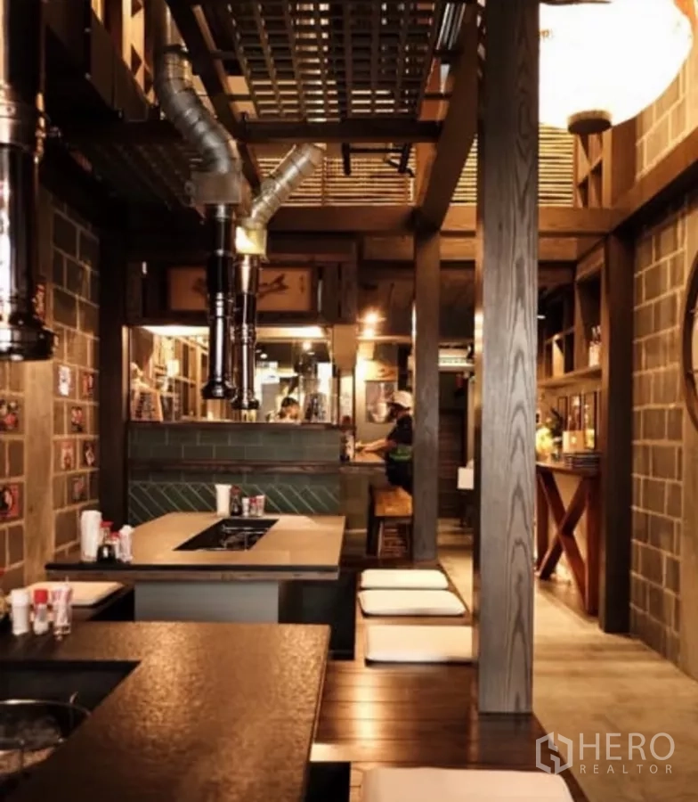 Shophouse for rent in Bang Rak, Bangkok - Warm timber-and-brick interior with built-in tables and ventilation ducts, ideal for F&B.